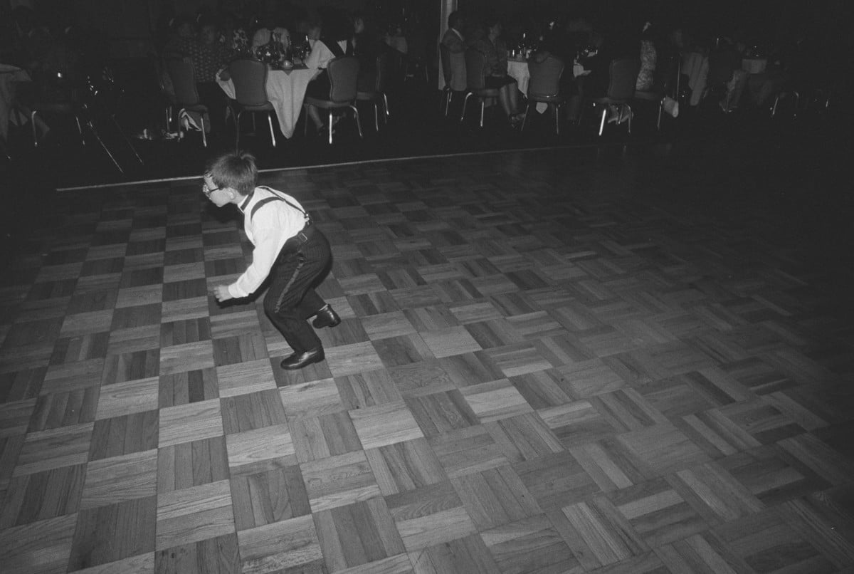 The ring bearer dancing alone on the parquet dance floor at a 1989 wedding reception