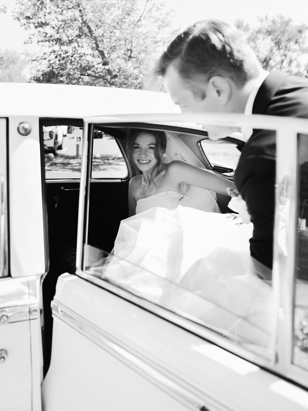 Black and white photo of Baylee arriving at the church in a vintage Bentley