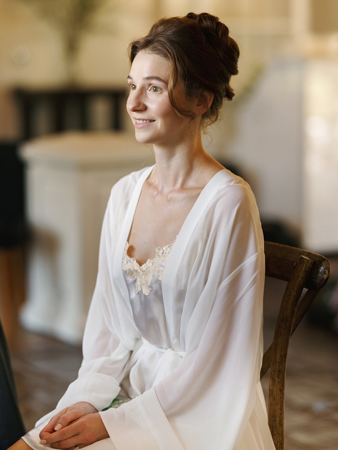 Baylee in a white robe by the window while getting ready at La Venta Inn