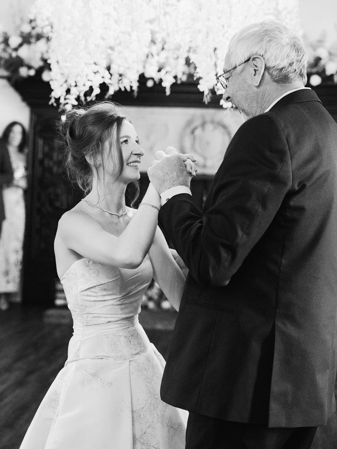 Black and white photo of Baylee dancing with her dad at the reception