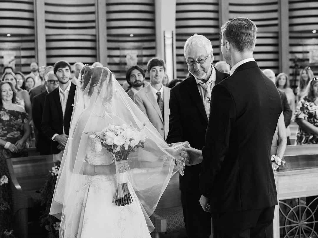 Black and white moment of Baylee's dad giving her away at the altar