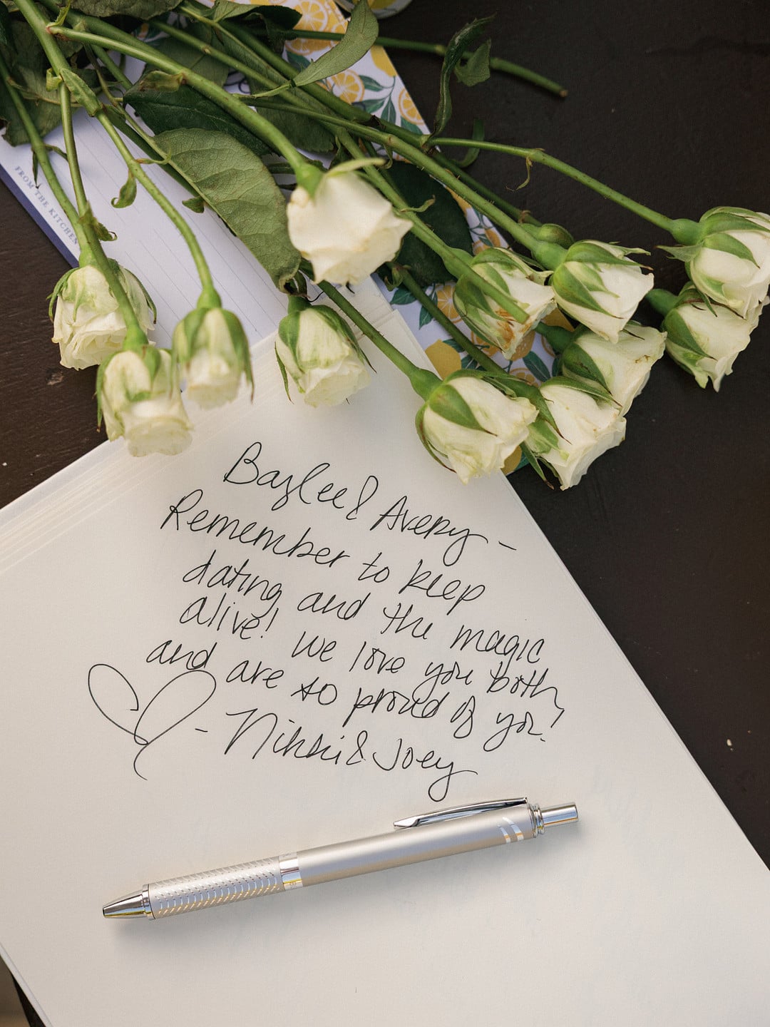 A handwritten guest book note telling Baylee and Avery to keep dating and the magic alive