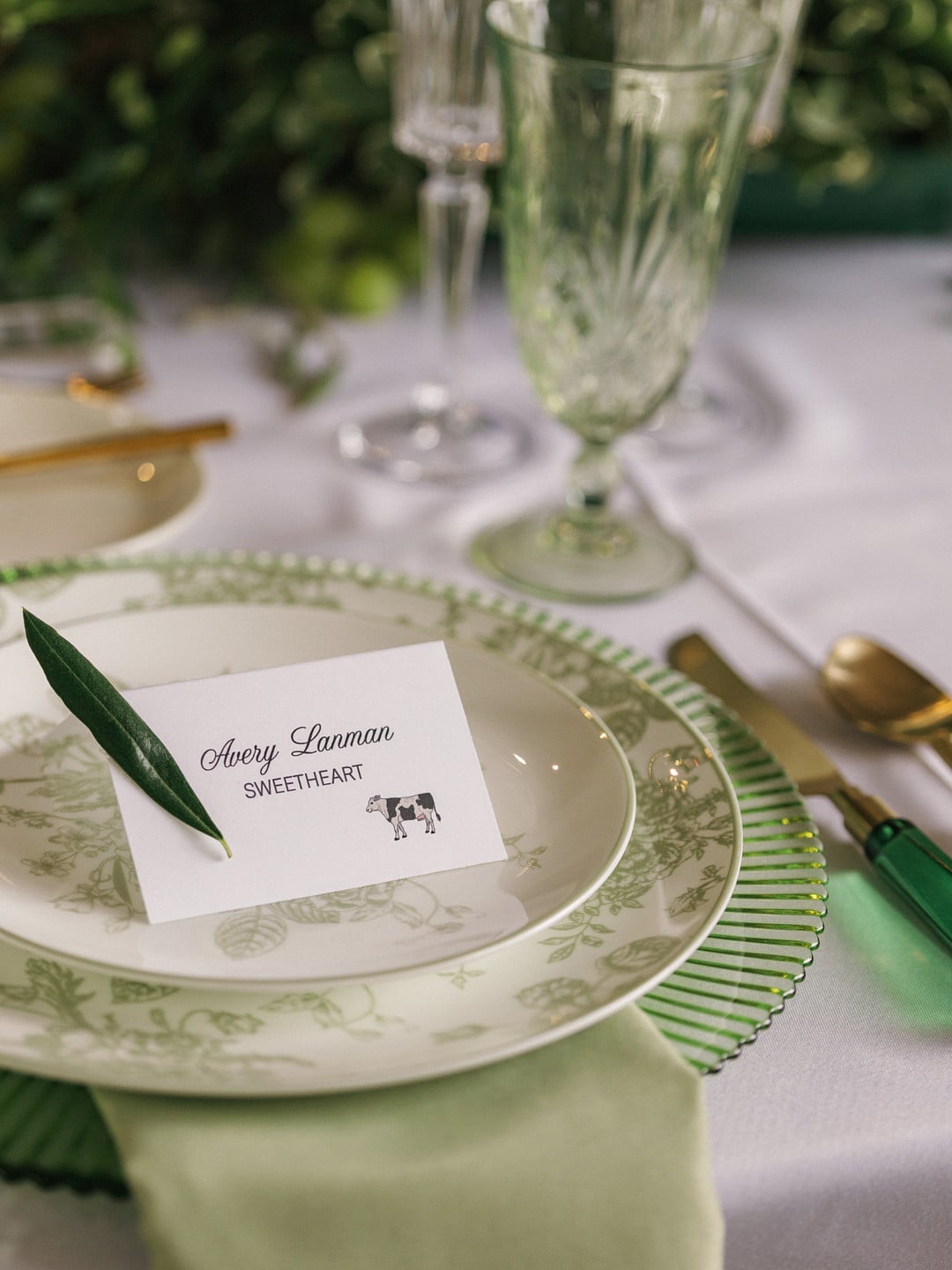 Avery's place card at the sweetheart table on green and white toile china