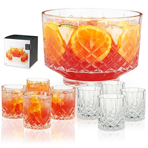 A cut crystal punch bowl set filled with punch, with eight matching tumblers
