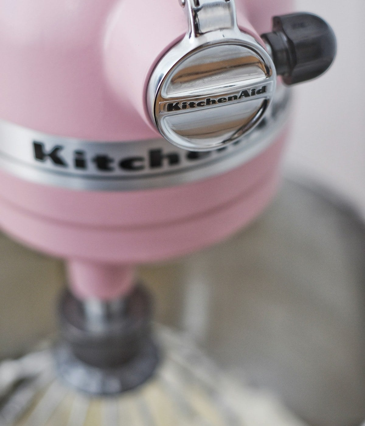 A pink KitchenAid stand mixer with batter in the bowl