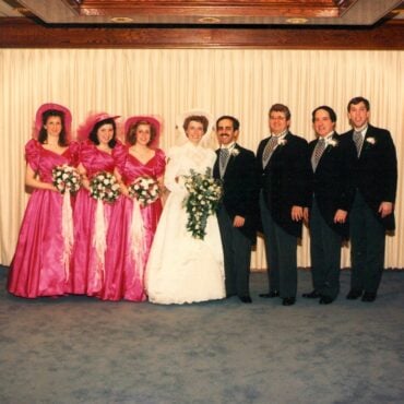 1988 wedding party: bride and groom with bridesmaids in hot-pink satin puff-sleeve dresses and groomsmen in tails