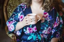 Bride in a floral robe holding a mug while getting ready