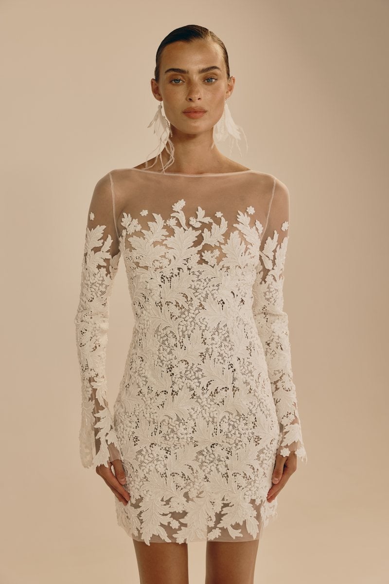 Mira Zwillinger Cici, a lace mini wedding dress with long illusion sleeves